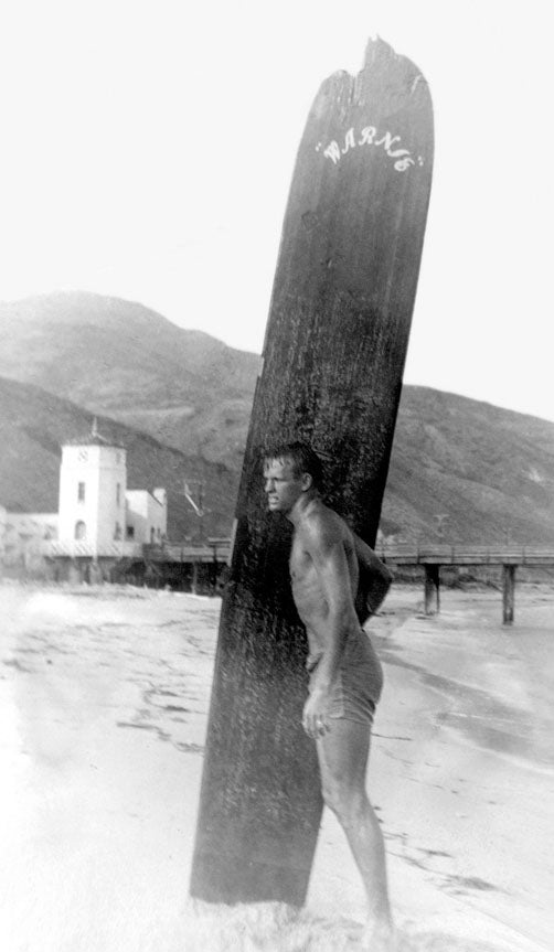 SKI1016_WarrenMiller03 Warren, nicknamed “Warnie” by his surfing buddies, with the broken-nosed surfboard he built in 1947 after leaving the Navy. It was 11 feet long and…