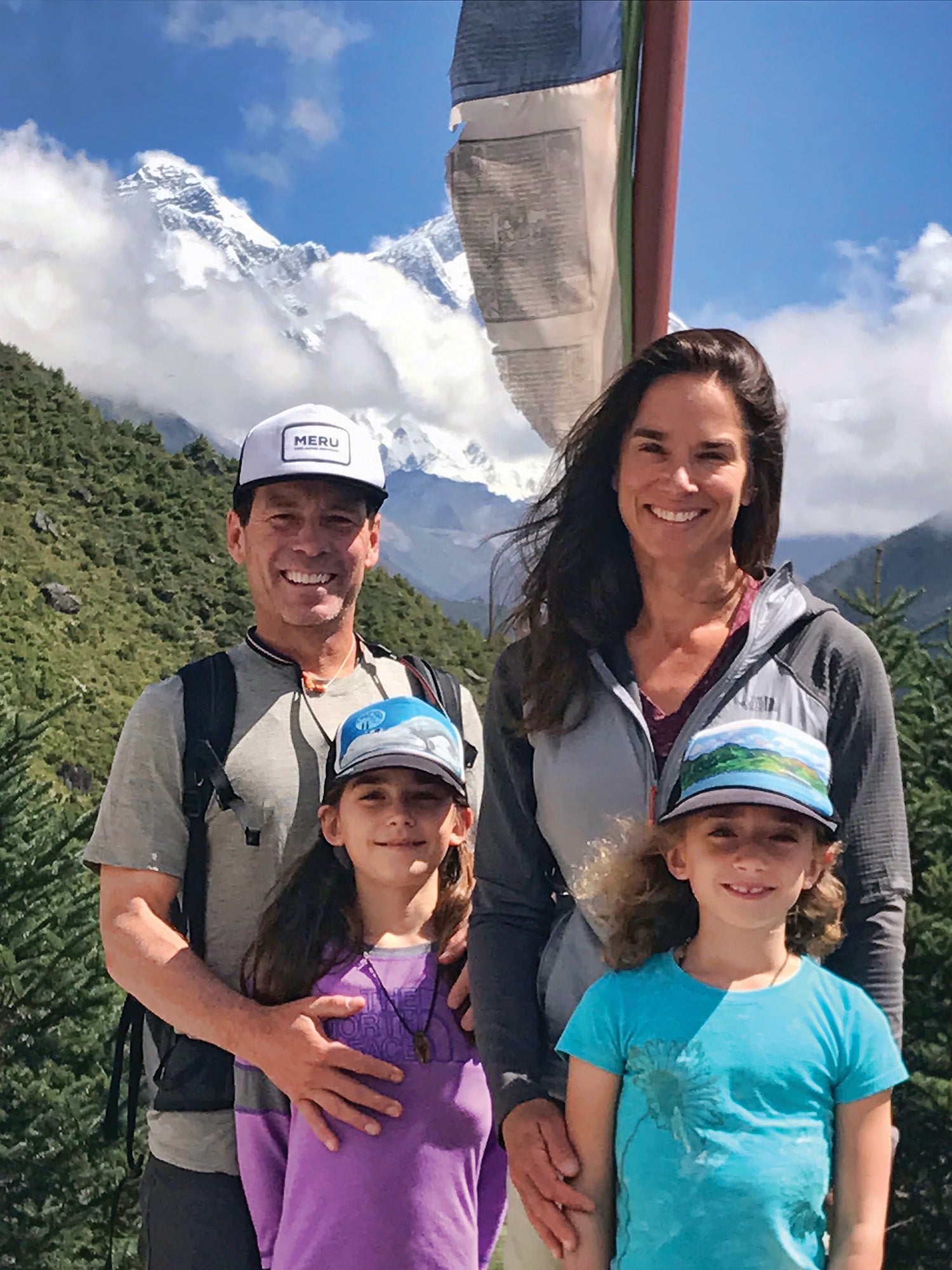 SNW70-Jackson4-coKitDeslauriers copy Kit and Rob Deslauriers and their two children smiling in front of green mountain range