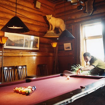 Playing Pool DOWN TIME A friendly game at the rustic Num-Ti-Jah Lodge.