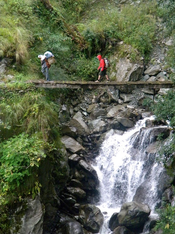 Wooden Bridge A porter and Kip Garre crossing a creaky wooden bridge in the rainy jungle.