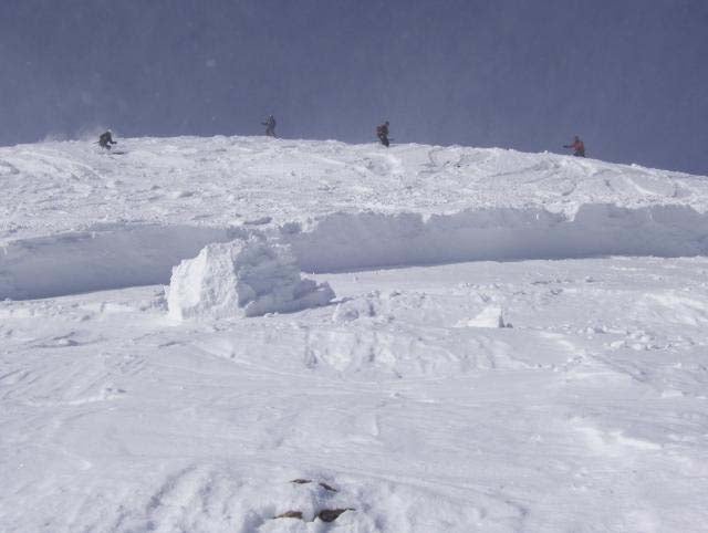 Saddle Peak 3 A view of the crown as skiers descend to begin a beacon search. The portion of snow remaining is called hangfire. It poses its own avalanche risk…