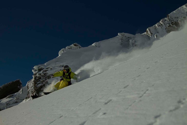 Sam Smoothy slashes a line Sam Smoothy, New Zealand local, skis the snow with Southern Lakes Heli.