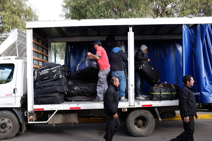 Drivers load up cargo trucks with skis and gear after participants arrived in Santiago. None