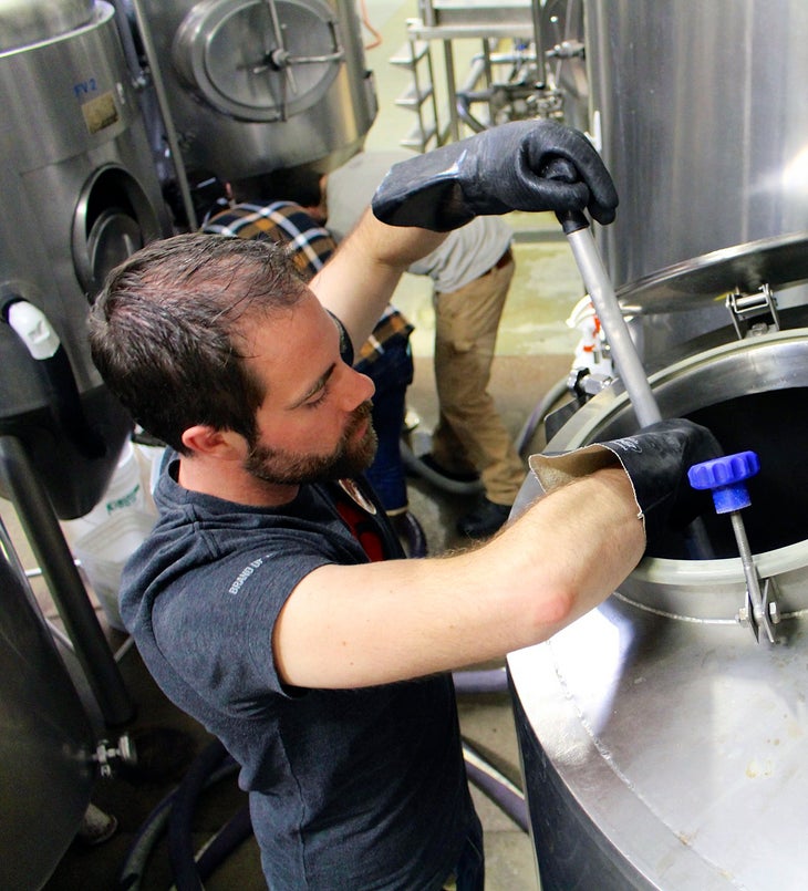 Final Stir With everything mixed in and boiled to perfection, it was time to transfer the wort to the holding barrel. One final stir and we sent our beer off to…