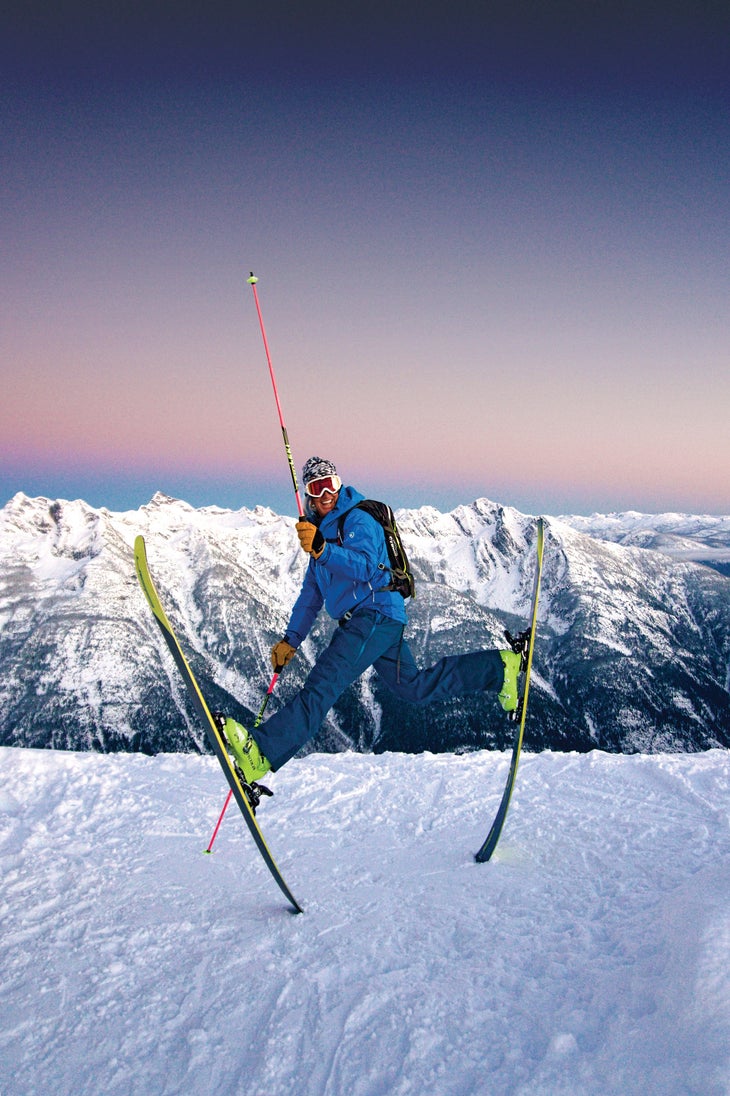 SNW70-Plake1-DannyDeclare copy Skier Glen Pake jumping into the air with his skis on and one pole raised up in front of a snow mountain range