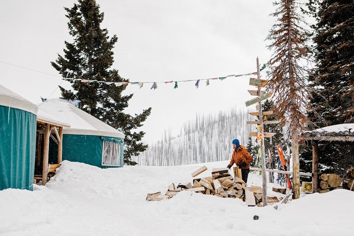 SKI1219-EC-YurtsCoyote-3-byRayJGadd-s Man gathering wood outside Coyote Yurt in Sun Valley, Idaho