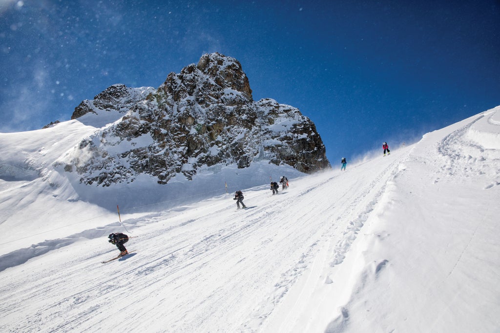 "Skiers racing down a slope at the Derby De La Meije"
