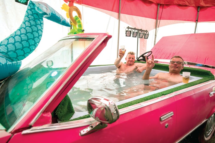 WEB SKI1219-Derby1507-byChristofferSjostrom copy Two men sitting in a car that has been made into a hot tub at the Derby De La Meije