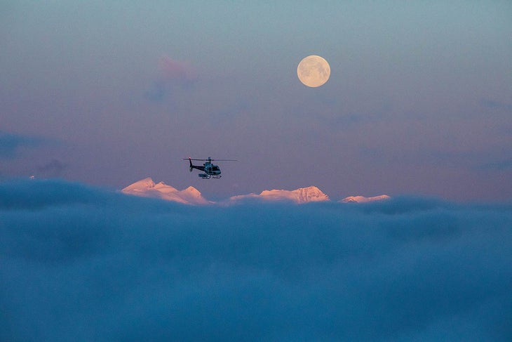 SKI0120-REVY-12-byRyanCreary-s Sunrise and a full moon over the Monashees as the first flight arrives to take guests out of Selkirk Mountain Experience at the Durrand Glacier