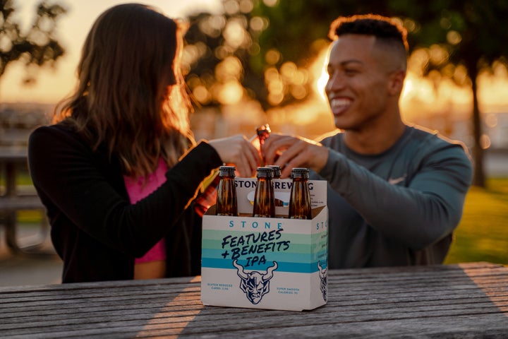 Two people drinking Stone Features + Benefits IPA