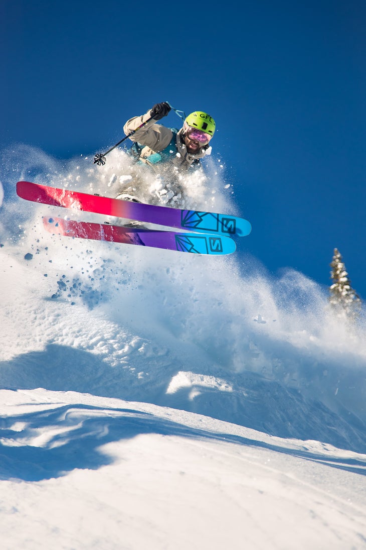 Photo of skier jumping through powder on the 2022 Salomon QST Blank skis