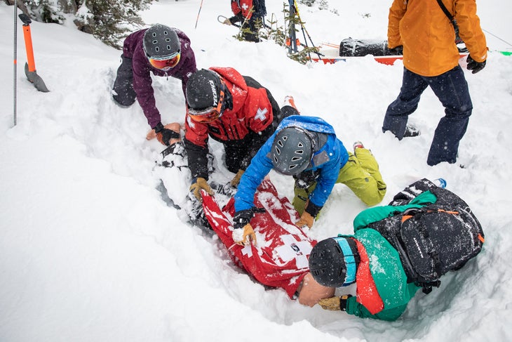 a team packages a dummy in an avalanche scenario