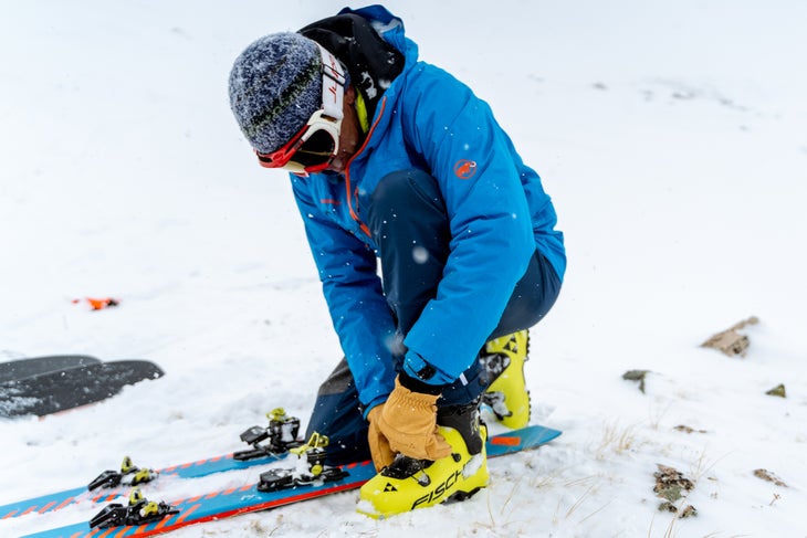 Skier adjusting their ski boots.