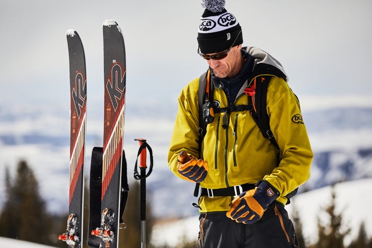 A skier checks his beacon