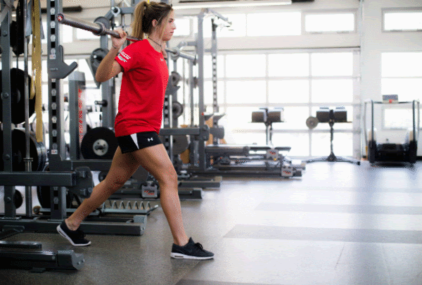 Athlete performs barbell split move in gym