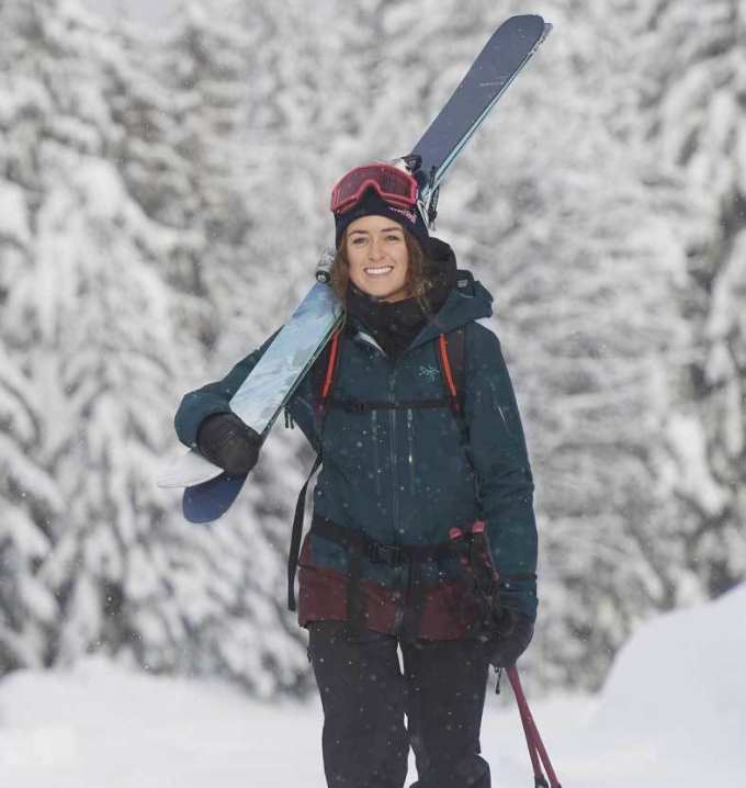 Skier with pair of Rossignol Rallybird Ti skis on shoulder