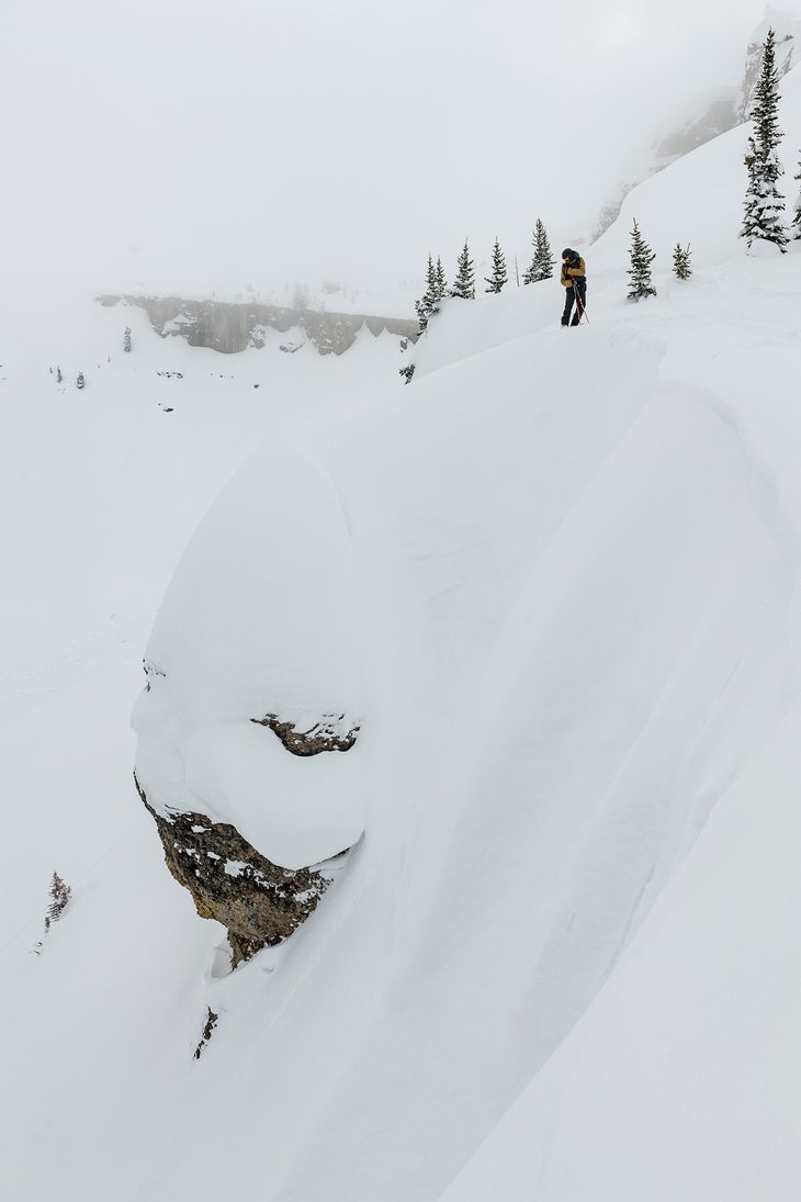 Man standing above a snowy cliff