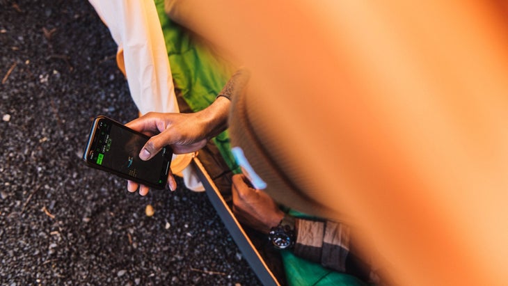 Man checking his phone in a tent