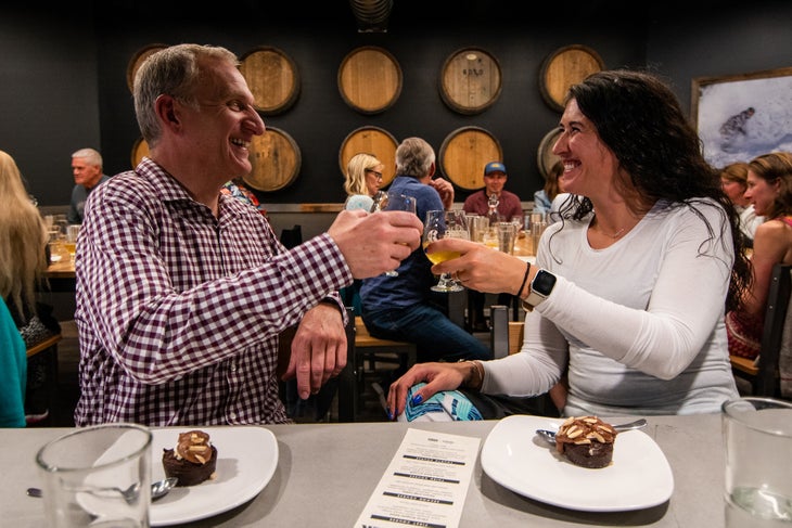 Two people clinking beer glasses