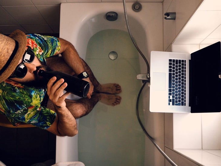man in tub with computer