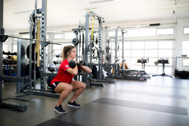 Athlete performs loaded front squat in gym