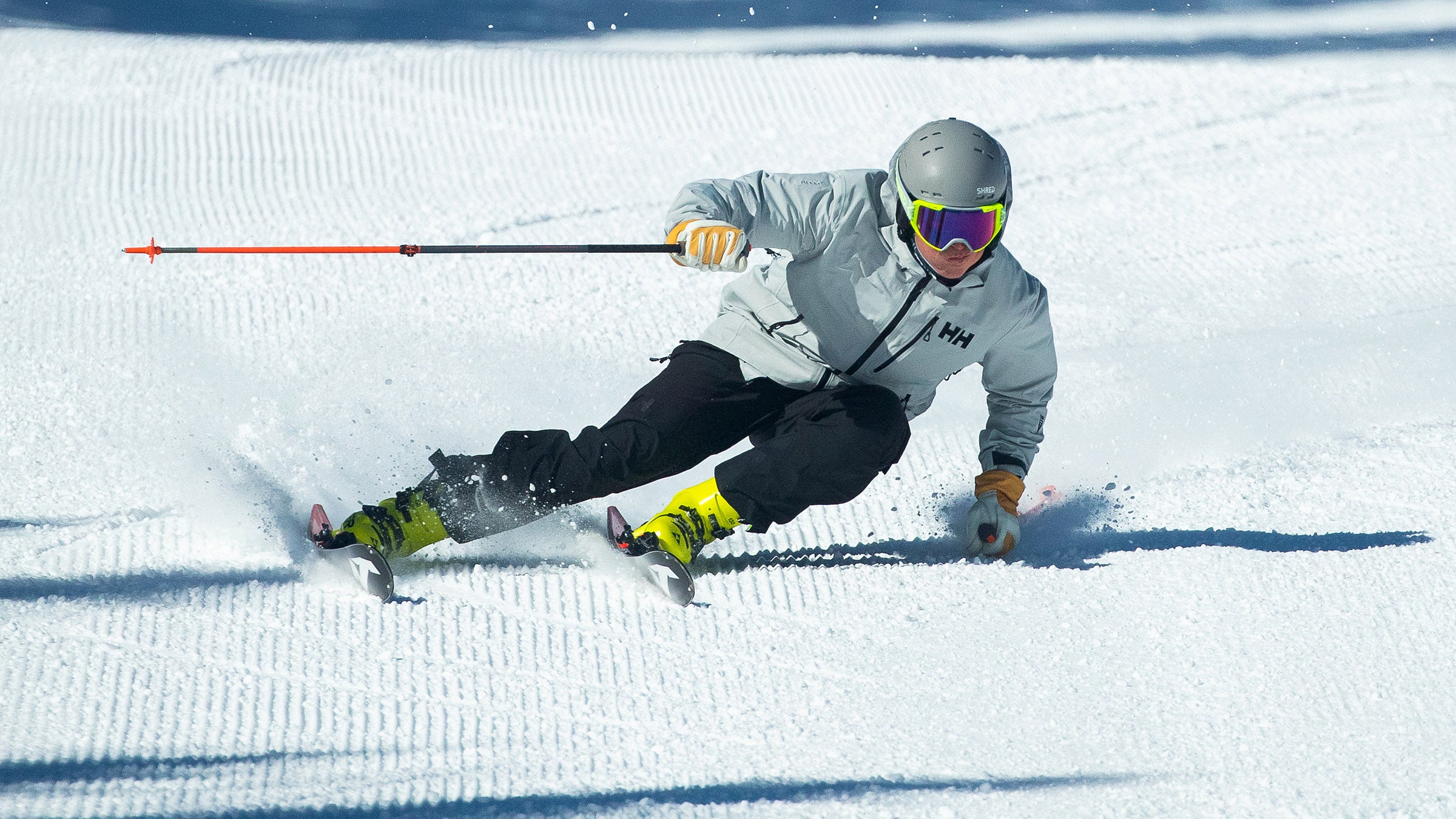 Very good skier carving on skis with high edge angles down a snowy run.