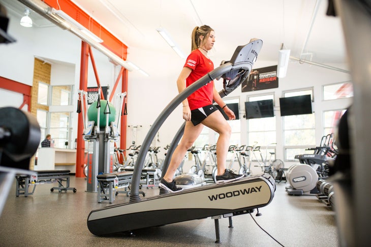 Athlete climbs on treadmill at gym
