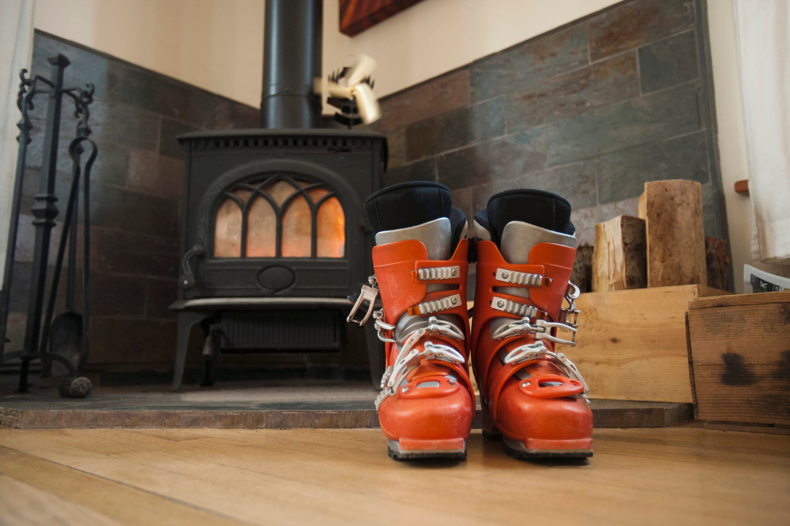 red ski boots in front of wood stove.