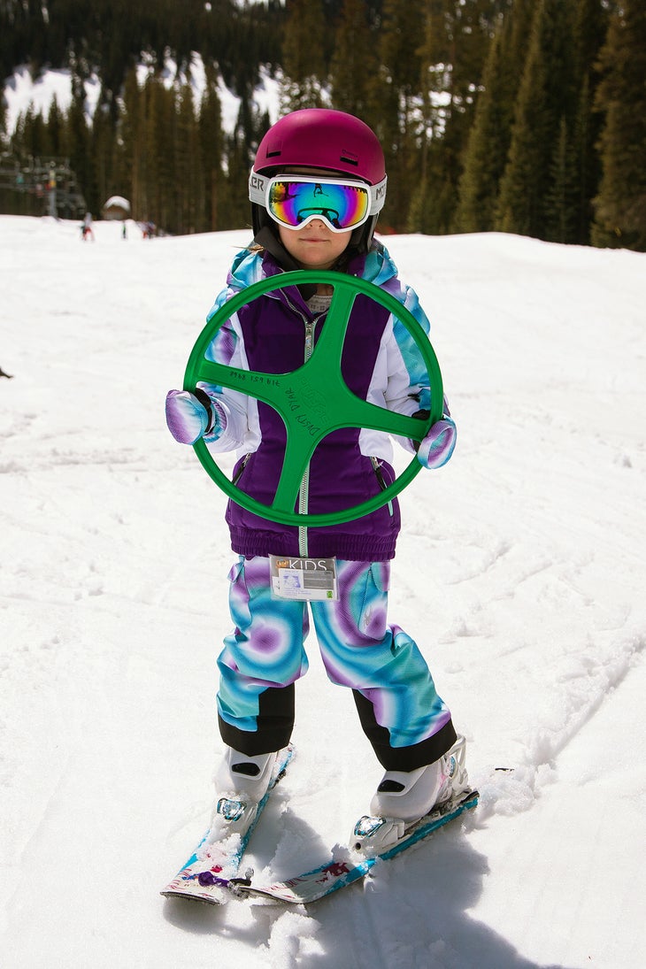 Kid skiing with steering wheel teaching tool