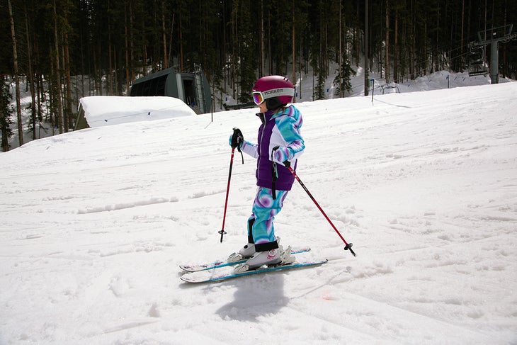 Kid skiing with poles