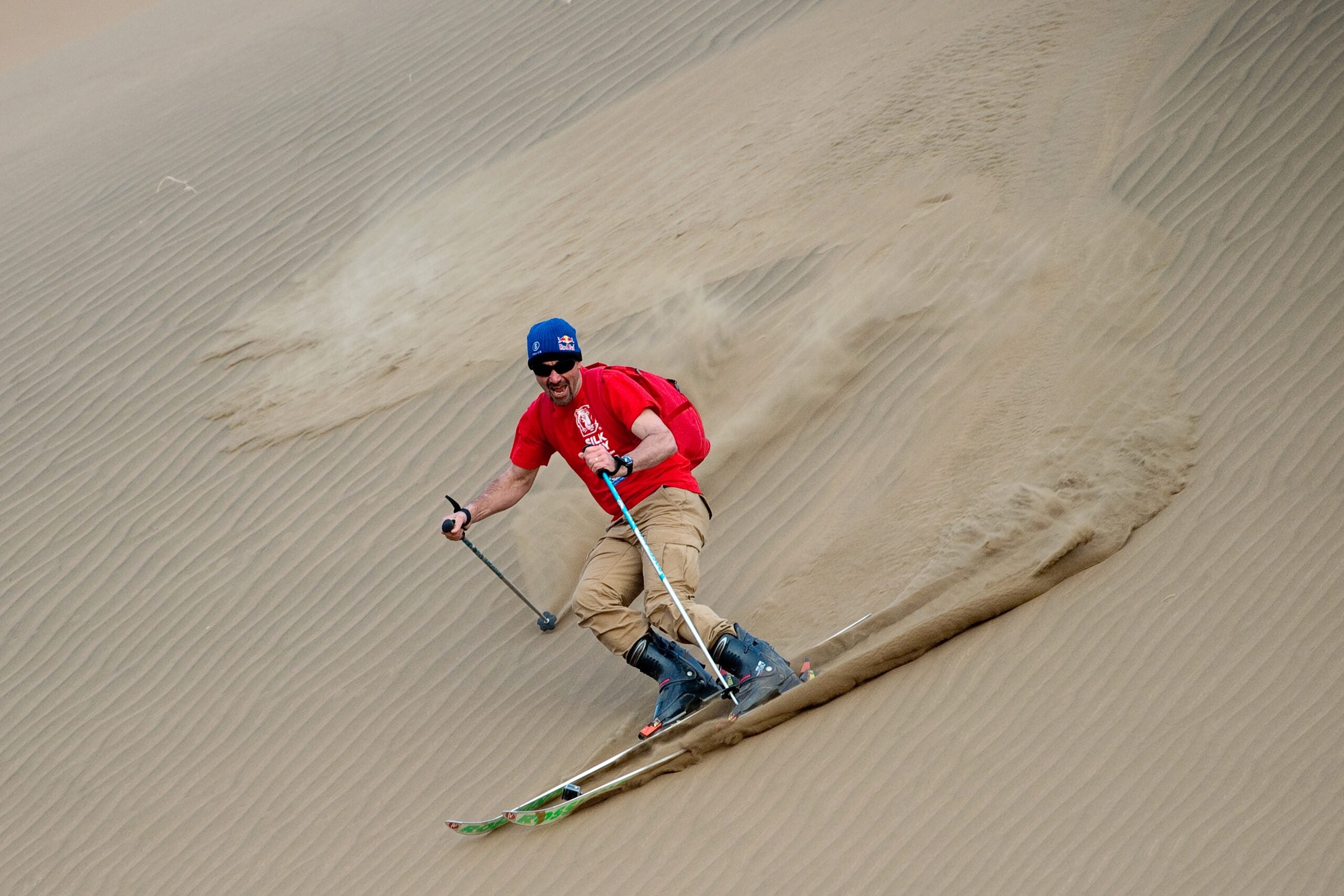 TOPSHOT - This picture taken on April 20, 2016 shows French former overall Ski World Cup winner and race car driver Luc Alphand skiing down a big sand dune during an off-road mapping recognition excercise ahead of the Silk Way Rally 2016 in the Gobi desert, some 2,000 kms (1250 miles) northwest of Beijing. 
The 2016 Silk Way Rally takes place in July and will see competitors race from Moscow's Red Square to the Chinese capital Beijing. / AFP / NICOLAS ASFOURI        (Photo credit should read NICOLAS ASFOURI/AFP via Getty Images)