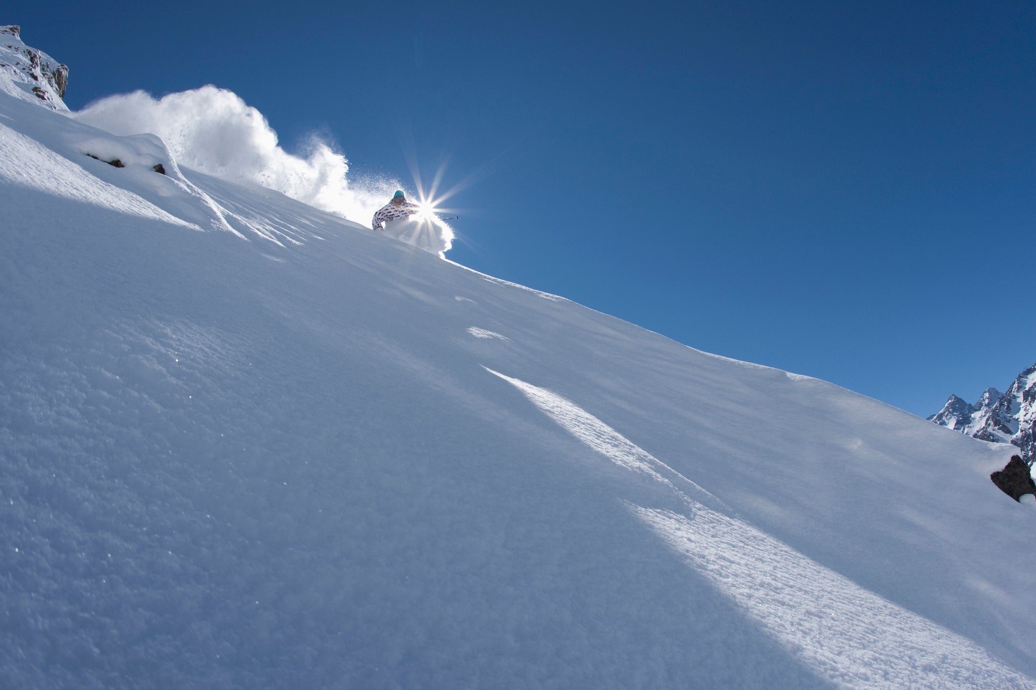 Chris Benchetler skiing perfect powder on a sunny day.