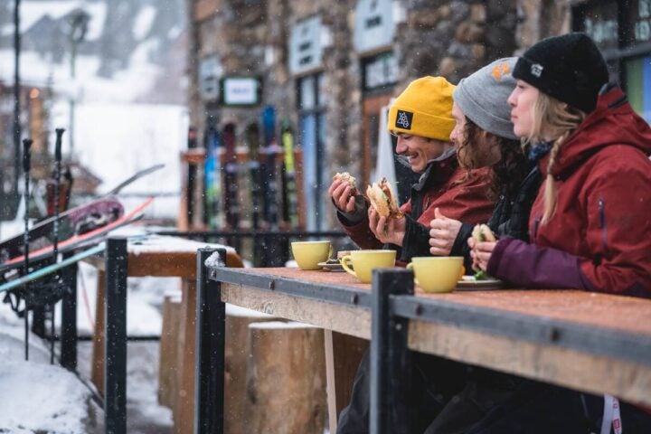 A trio of skiers enjoying lunch and coffee at Kicking Horse Mountain Resort.