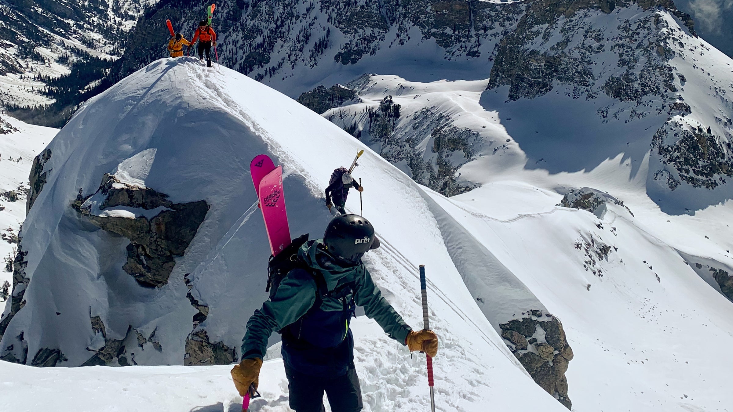 Backcountry skiers bootpacking in alpine touring boots on a mountain ridge