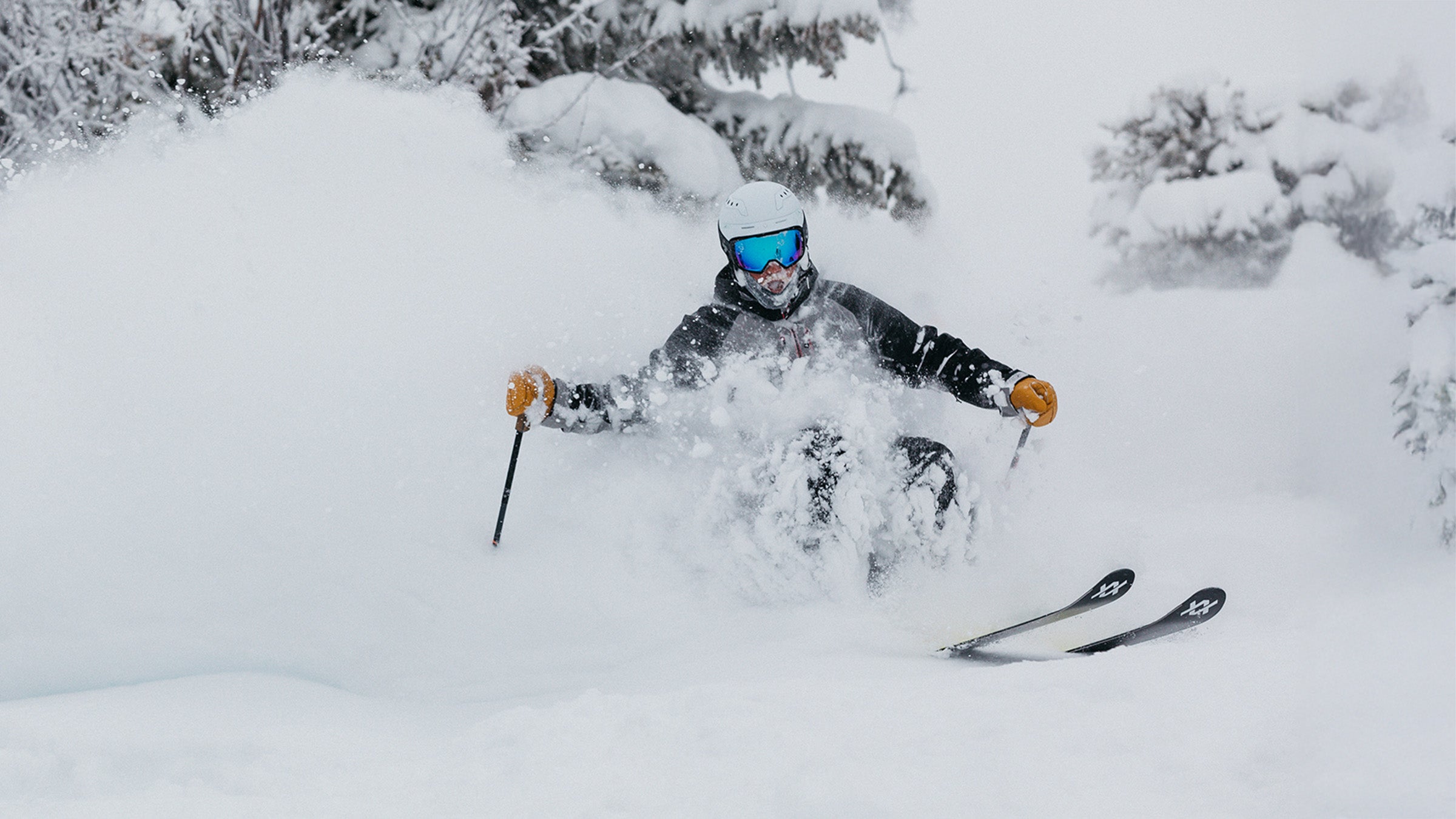 Skier turning in deep snow on powder skis during SKI's annual gear test