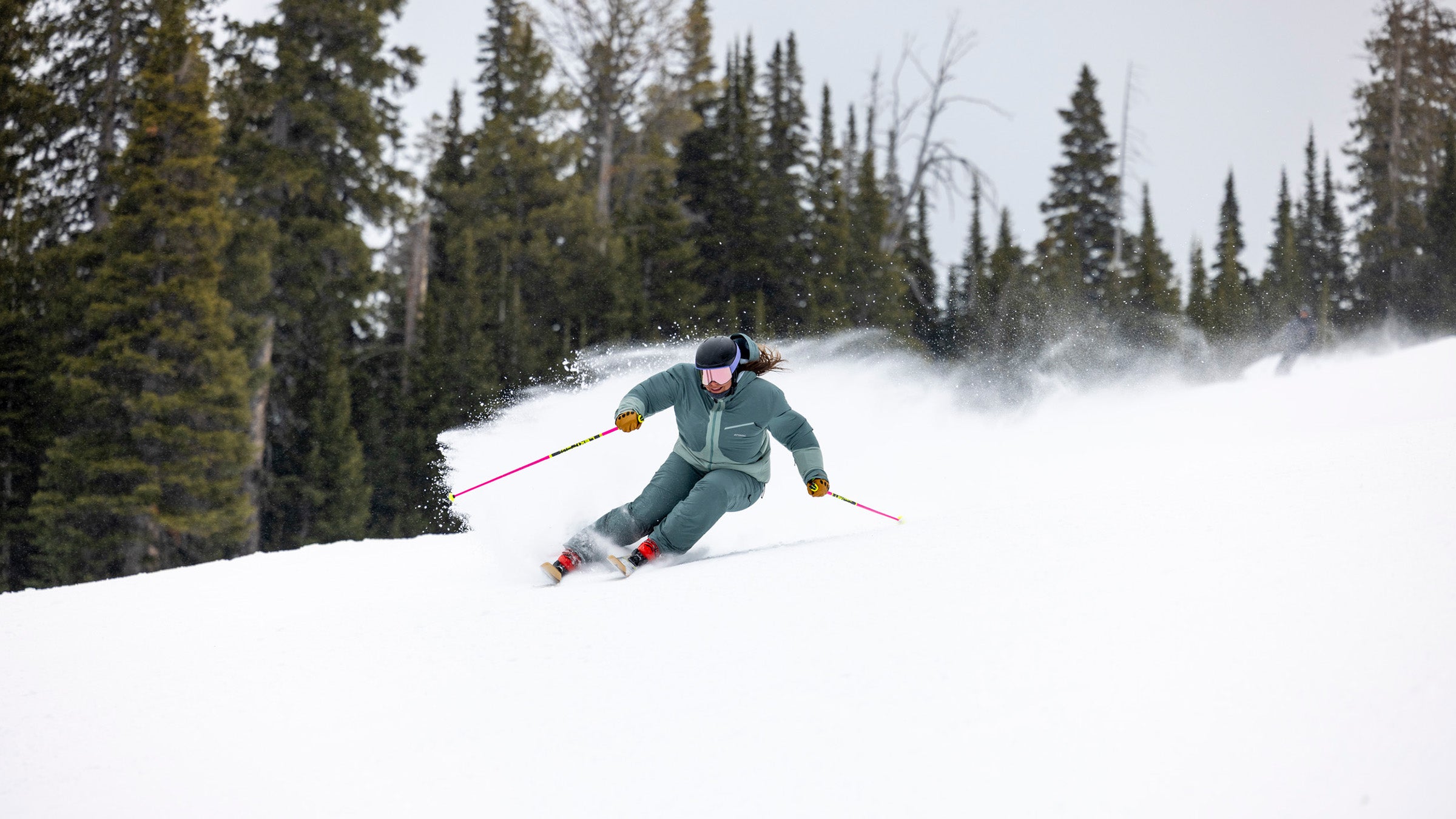 Woman in green skiing on snow