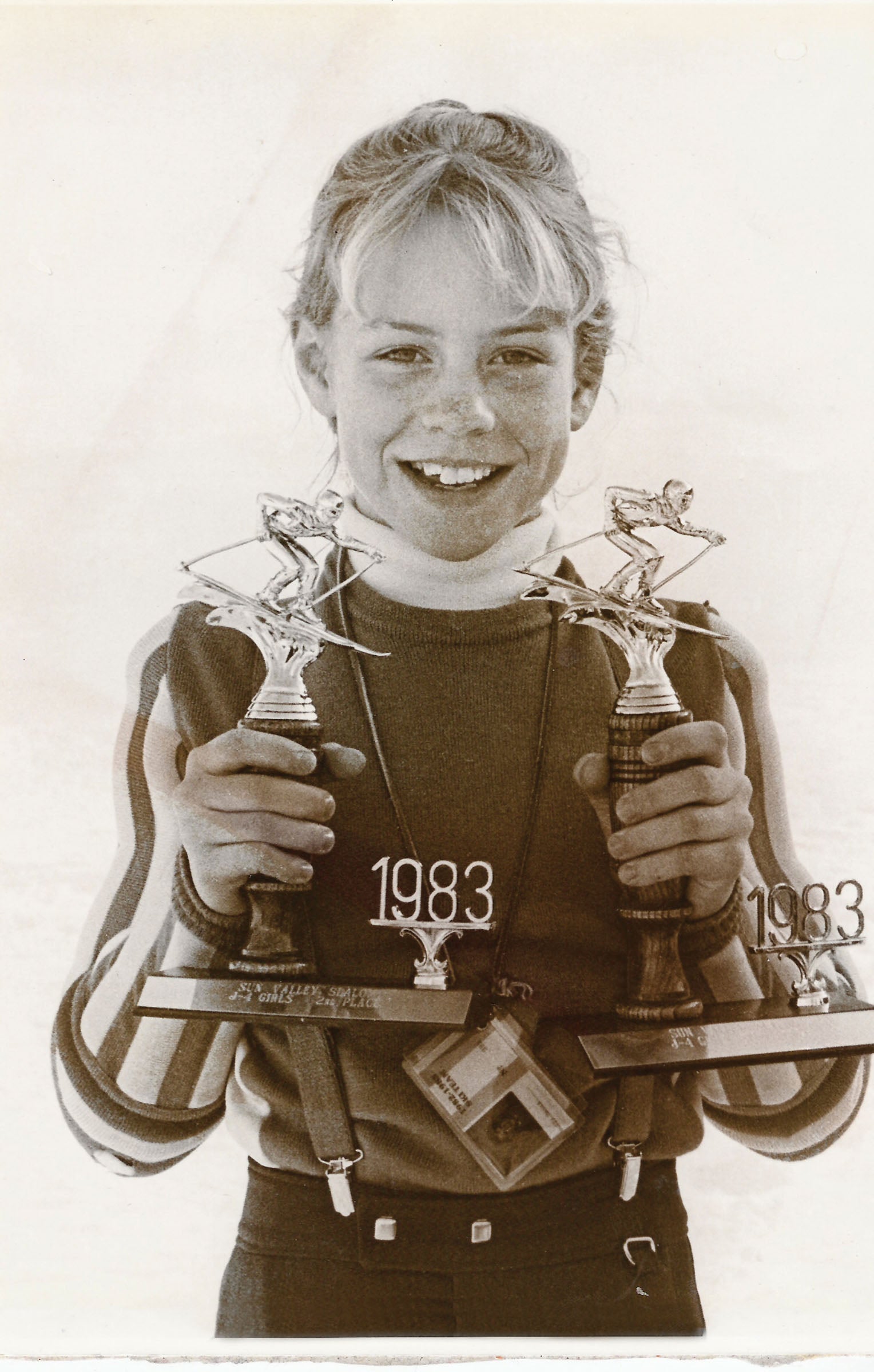 SKI1119-PRO3-MuffyDavis_v1_1 copy A young Muffy Davis holding two skiing trophies that say 1983