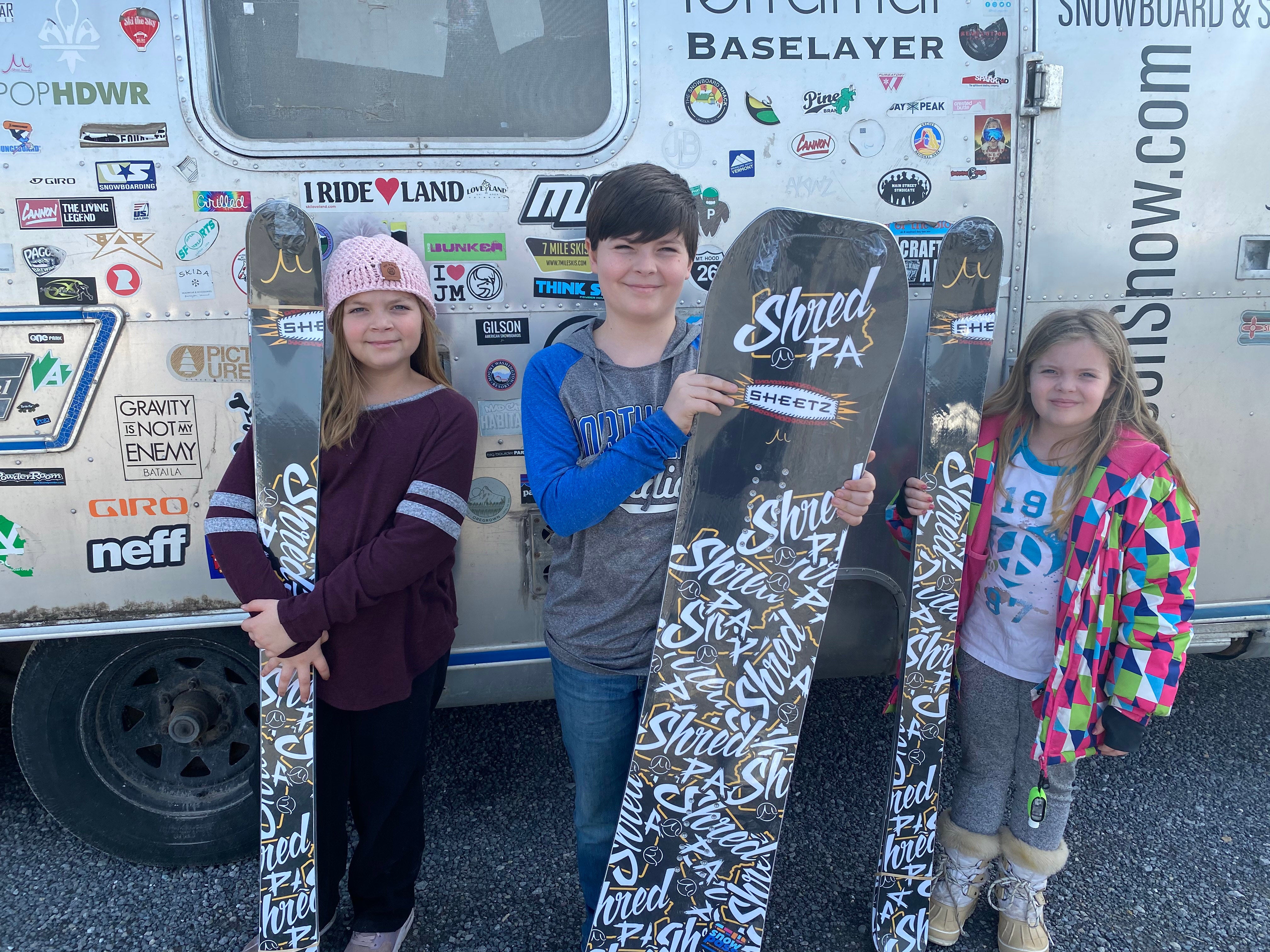 Shred PA Photo 3 Three participants in the SkiPA 4th and 5th Grade Snowpass Program hold up their free skis and snowboards from Gilson Snow